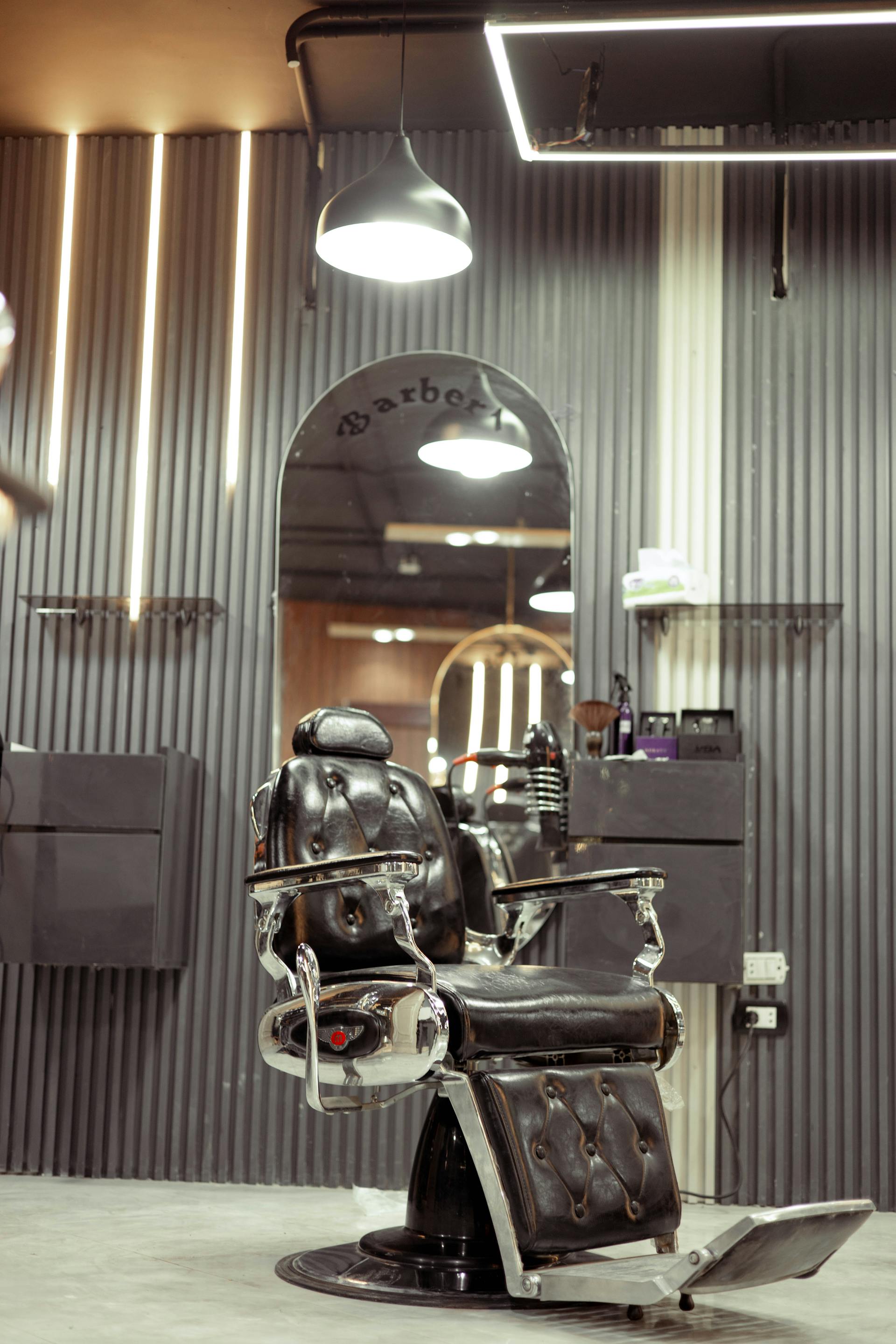 Empty leather barber chair under warm tungsten light at 247 Irving